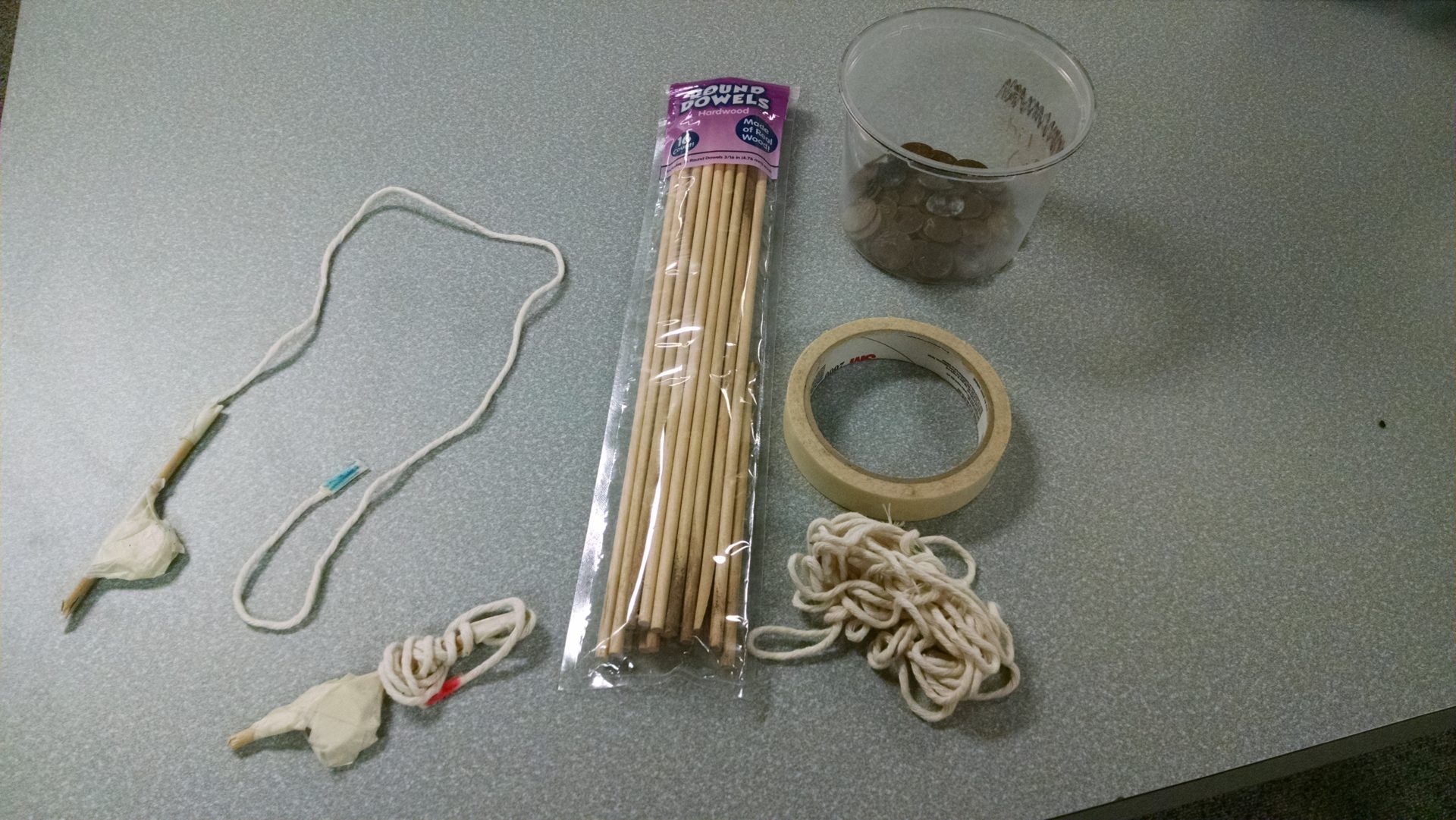 Twine, wooden dowel, masking tape, and pennies.