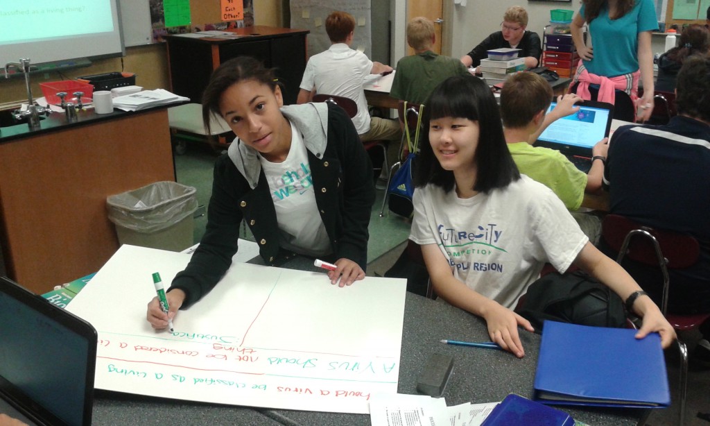 One group of students begins defending their claim to whether viruses are living or non-living. Their evidence and justification were a key part of their boards that they were assessed for.